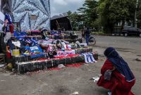Seorang perempuan meratapi tragedi Kanjuruhan di dekat Tugu Aremania di depan Studio Kanjuruhan, Malang. (Foto: istimewa)