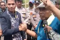 Rahman korlap aksi  saat memberikan satu renteng kemasan sachet produk tolak angin yang dihadiahkan kepada Kasi Pidana Khusus (Pidsus) Kejari Bangkalan