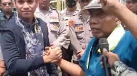 Rahman korlap aksi  saat memberikan satu renteng kemasan sachet produk tolak angin yang dihadiahkan kepada Kasi Pidana Khusus (Pidsus) Kejari Bangkalan
