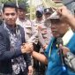 Rahman korlap aksi  saat memberikan satu renteng kemasan sachet produk tolak angin yang dihadiahkan kepada Kasi Pidana Khusus (Pidsus) Kejari Bangkalan