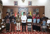 Bupati Pamekasan Kholilurrahman menyerahkan penghargaan kepada para juara MTQ XXXI Jawa Timur di Peringgitan Dalam Rumah Dinas Bupati, Rabu (8/10/2025).
