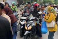 MERAKYAT: Perngurus DPD Partai Golkar Sumenep saat bagi-bagi ratusan paket takjil dan nasi kotak kepada warga di Jalan Jendral Sudirman, Kamis (26/2/2026) sore. 