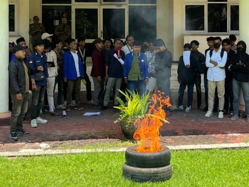 Mahasiswa PMII UIN Madura berunjuk rasa dengan membakar ban di depan Kantor Bupati Pamekasan, Kamis (12/3/2026), sebagai bentuk protes terhadap pengawasan Program Makan Bergizi Gratis (MBG).